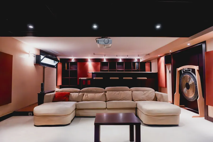 Salle cinéma avec grand canapé et bar